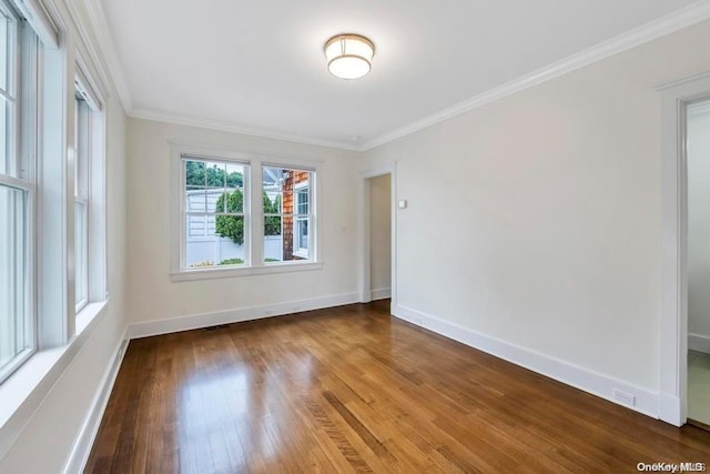 spare room with hardwood / wood-style floors and crown molding