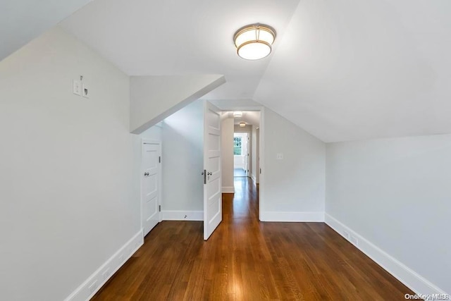 additional living space with dark hardwood / wood-style flooring and vaulted ceiling