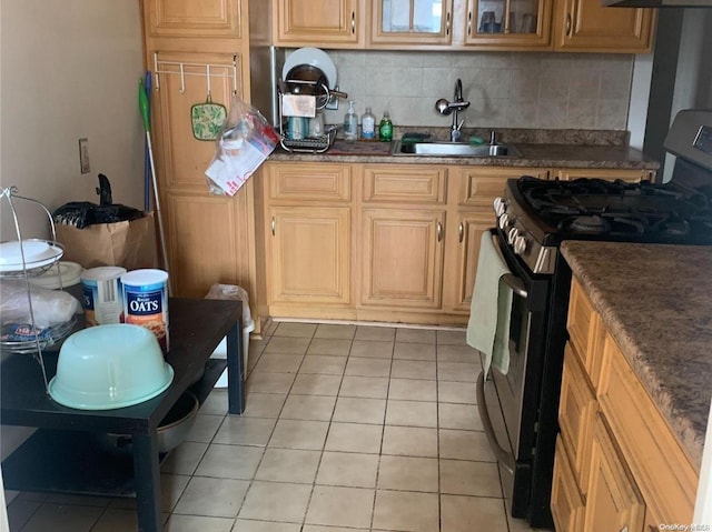 kitchen with light tile patterned floors, tasteful backsplash, black range, and sink