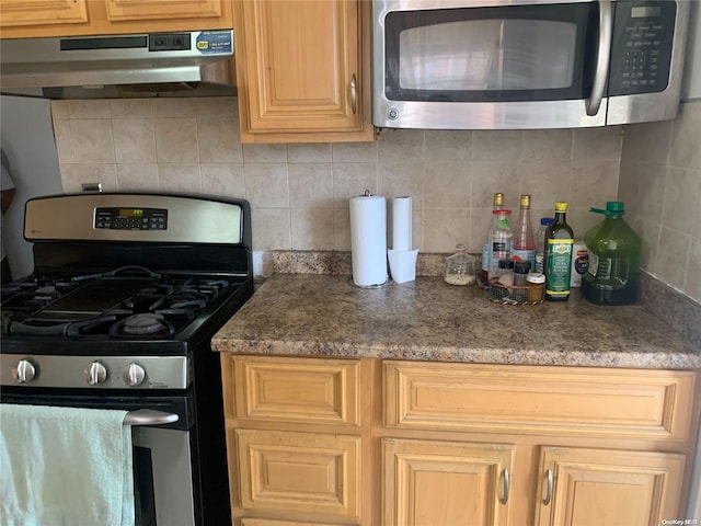 kitchen featuring light brown cabinetry, stainless steel appliances, and tasteful backsplash