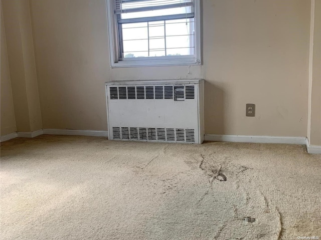 unfurnished room featuring carpet floors and radiator