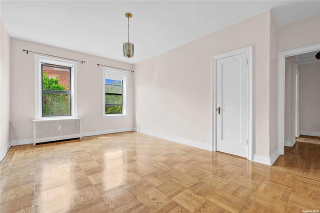 empty room with radiator heating unit and light parquet flooring