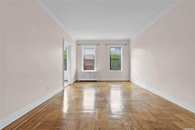 spare room featuring ornamental molding, radiator, and light parquet flooring