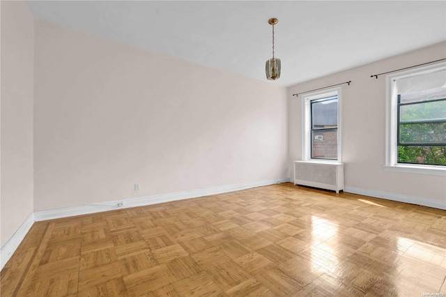 empty room featuring radiator heating unit and light parquet flooring