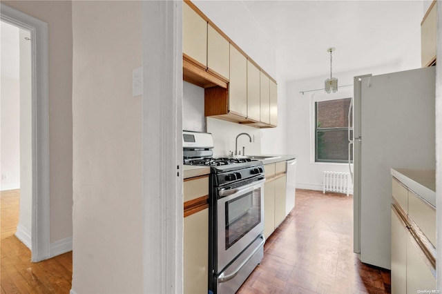 kitchen with gas range, radiator, light hardwood / wood-style flooring, refrigerator, and cream cabinetry