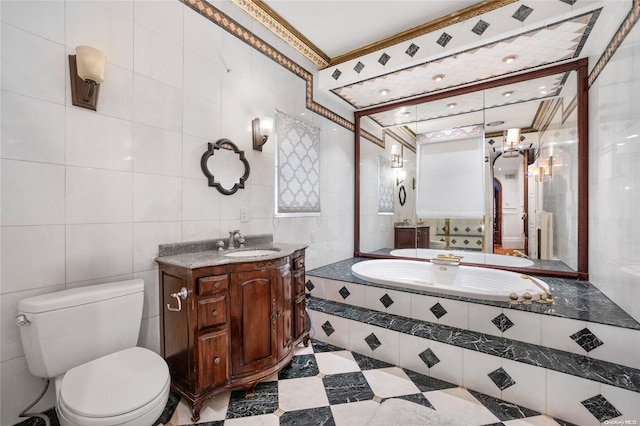 bathroom with tiled bath, vanity, tile walls, and toilet