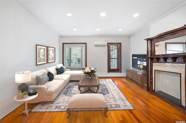 living room featuring wood-type flooring, a wall mounted AC, and crown molding