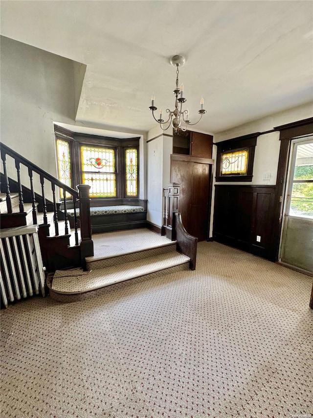 interior space featuring carpet and an inviting chandelier