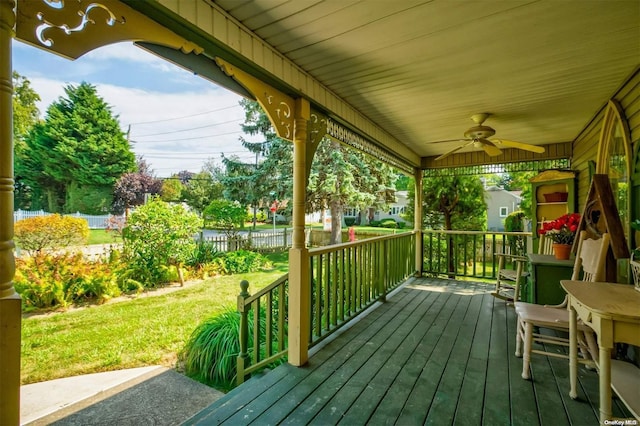 wooden terrace with a lawn, ceiling fan, and a porch