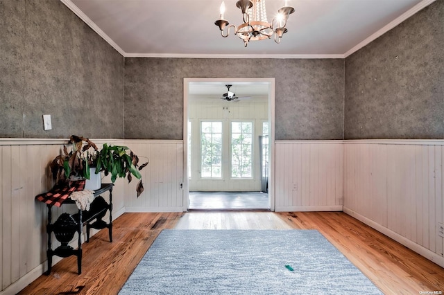 foyer featuring hardwood / wood-style flooring, ceiling fan with notable chandelier, and ornamental molding