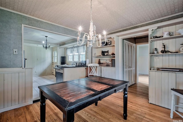 dining space featuring a chandelier, light hardwood / wood-style floors, and ornamental molding