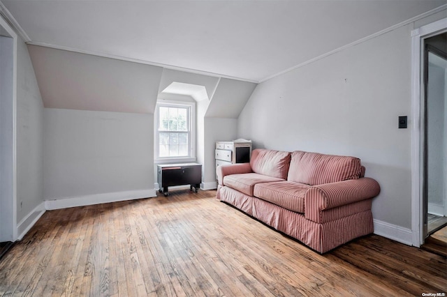 living room featuring wood-type flooring, crown molding, and vaulted ceiling