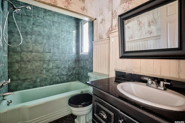 full bathroom featuring vanity, tiled shower / bath combo, and toilet