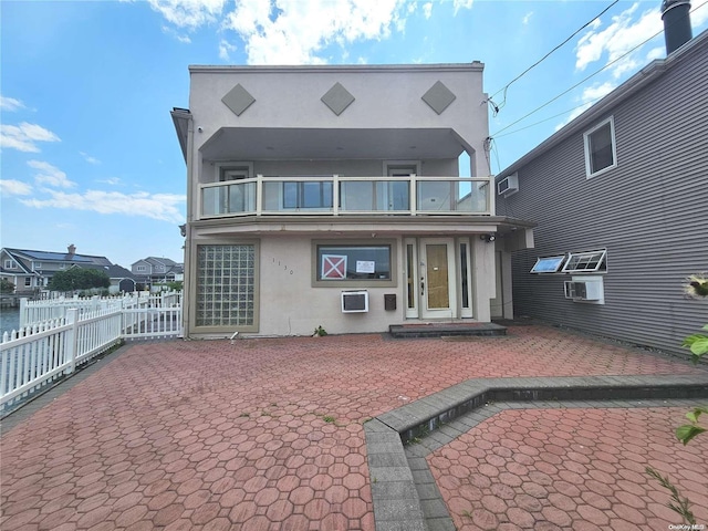 back of house featuring a balcony and a patio