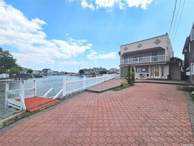 view of dock featuring a balcony, a patio area, and a water view