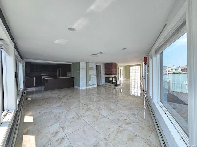 unfurnished living room featuring a fireplace and a water view