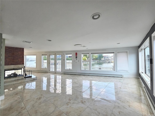 unfurnished living room with a water view, a fireplace, and a baseboard radiator