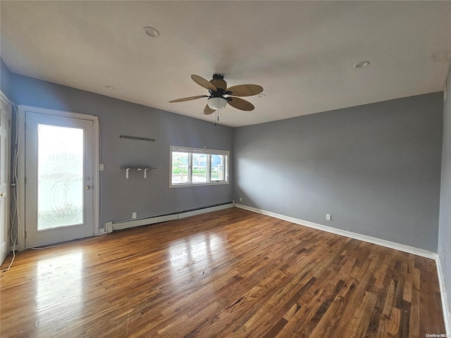 spare room with hardwood / wood-style flooring, baseboard heating, and ceiling fan