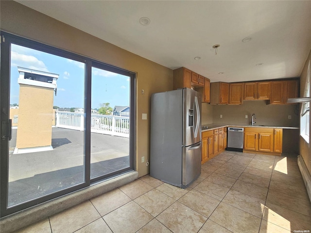 kitchen with light tile patterned floors, sink, appliances with stainless steel finishes, and tasteful backsplash