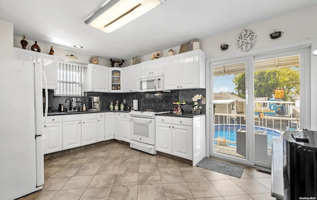 kitchen with decorative backsplash, white appliances, and plenty of natural light