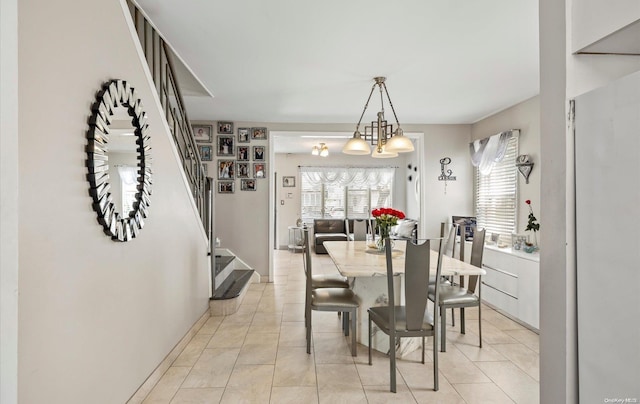 dining space with a notable chandelier and light tile patterned floors