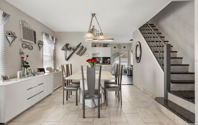 tiled dining room with a notable chandelier