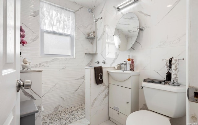 bathroom featuring vanity, toilet, tile walls, and a tile shower