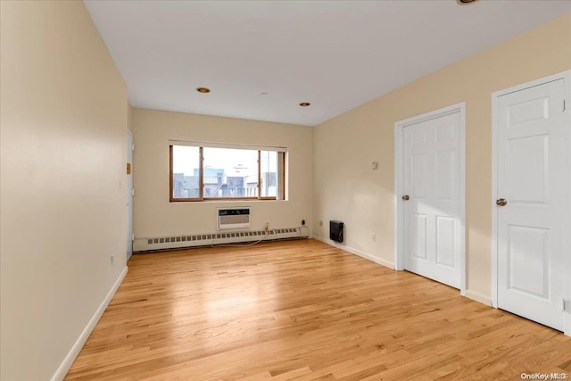 empty room with light wood-type flooring and baseboard heating