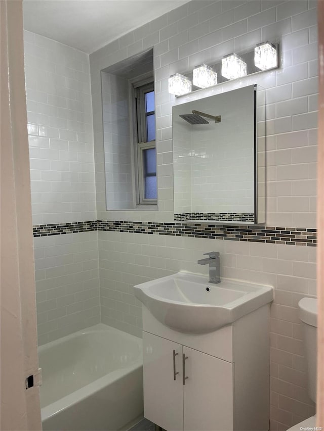 bathroom with shower / tub combination, vanity, and tile walls