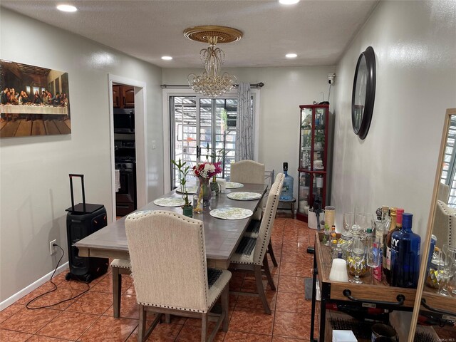 dining area with tile patterned floors and an inviting chandelier