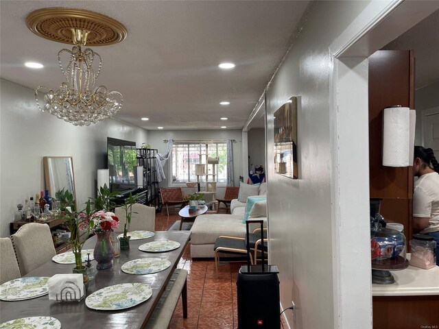 dining area with dark tile patterned flooring and an inviting chandelier