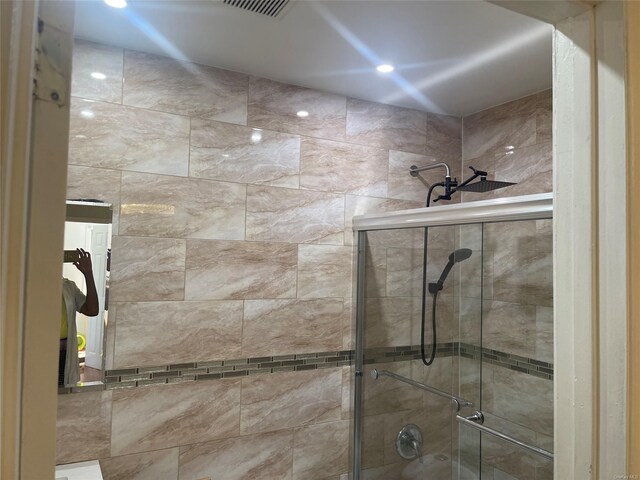 bathroom with a shower with door