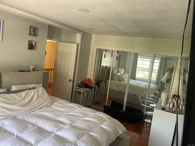 bedroom featuring wood-type flooring, a textured ceiling, and a closet