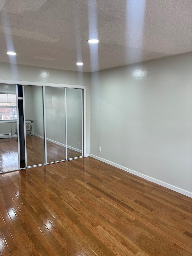 unfurnished bedroom featuring hardwood / wood-style floors and a textured ceiling