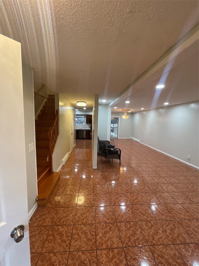 interior space with dark tile patterned flooring, baseboard heating, and a textured ceiling