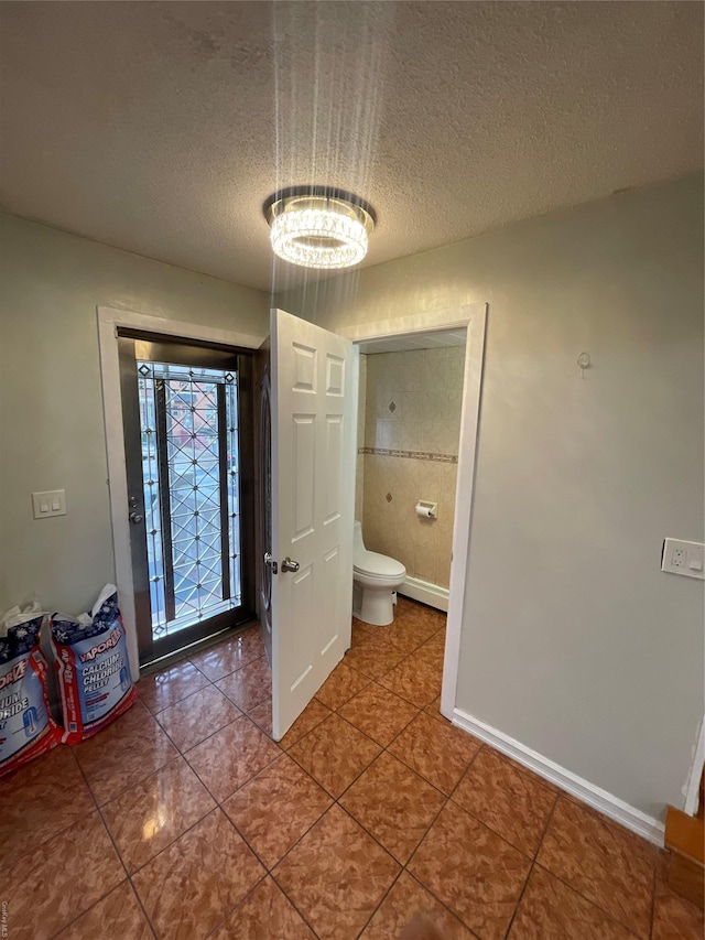 bathroom with tile patterned floors, a textured ceiling, and toilet