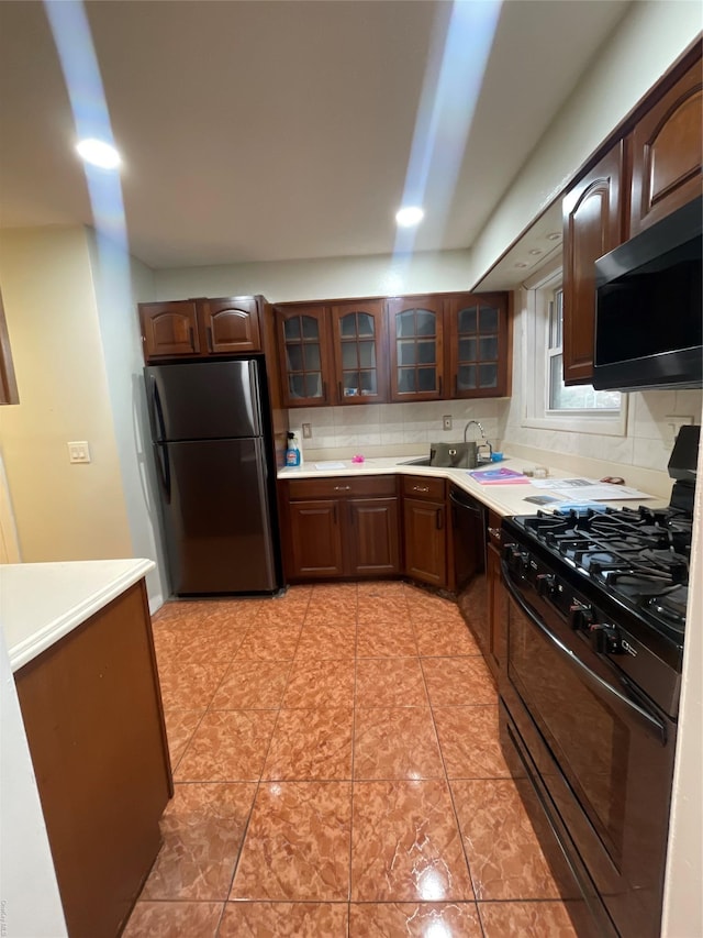 kitchen featuring black appliances, sink, light tile patterned floors, tasteful backsplash, and dark brown cabinets