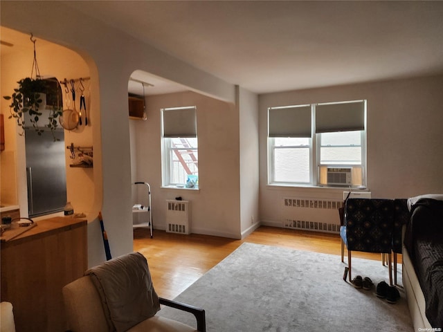 living area featuring radiator, cooling unit, and light hardwood / wood-style floors