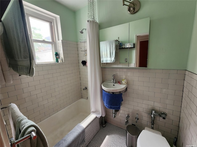 bathroom with toilet, tile patterned floors, shower / tub combo with curtain, and tile walls