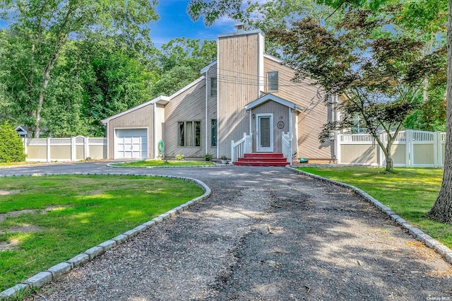 view of front of home with a garage and a front lawn