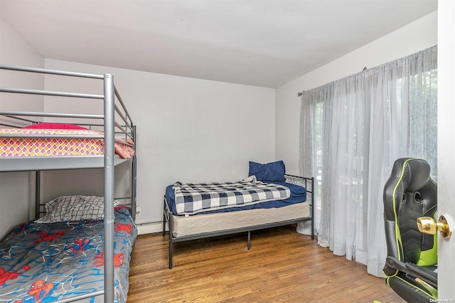 bedroom featuring hardwood / wood-style flooring and baseboard heating