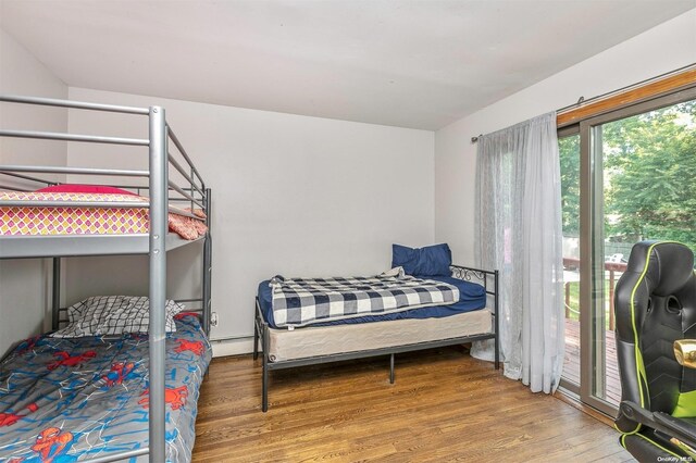 bedroom with hardwood / wood-style floors and baseboard heating