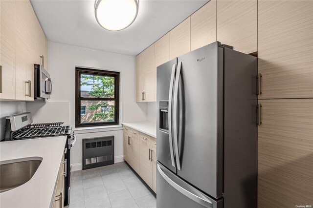 kitchen featuring sink, light tile patterned floors, tile walls, and appliances with stainless steel finishes