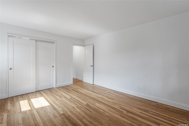 unfurnished bedroom featuring light hardwood / wood-style floors and a closet