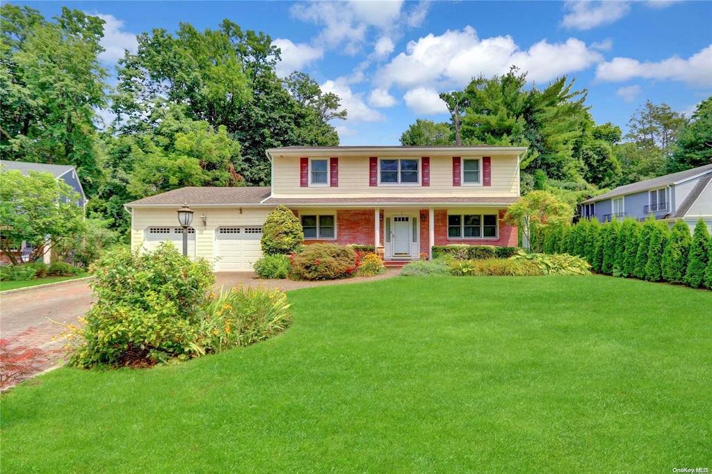 view of front of property with a front yard and a garage