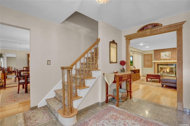 stairs with a fireplace and wood-type flooring