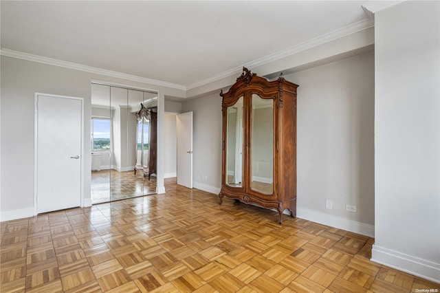 spare room featuring ornamental molding and light parquet flooring