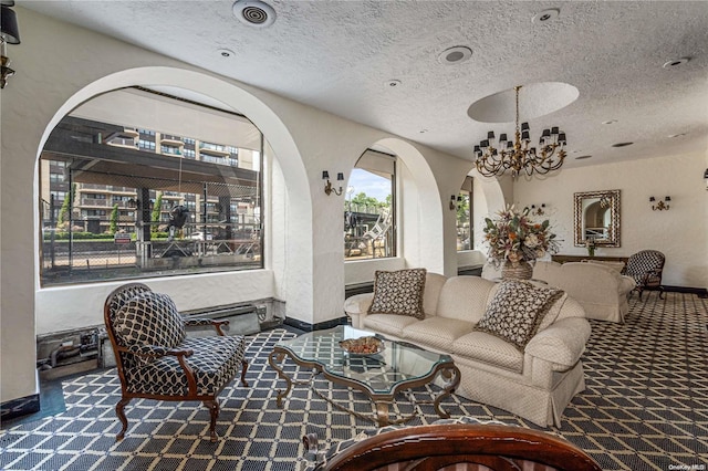 carpeted living room featuring a textured ceiling and a notable chandelier