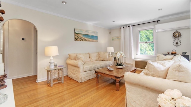 living room featuring a wall unit AC, crown molding, light hardwood / wood-style flooring, and radiator heating unit