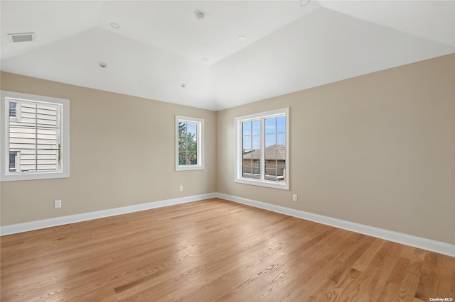 spare room with light hardwood / wood-style floors and high vaulted ceiling